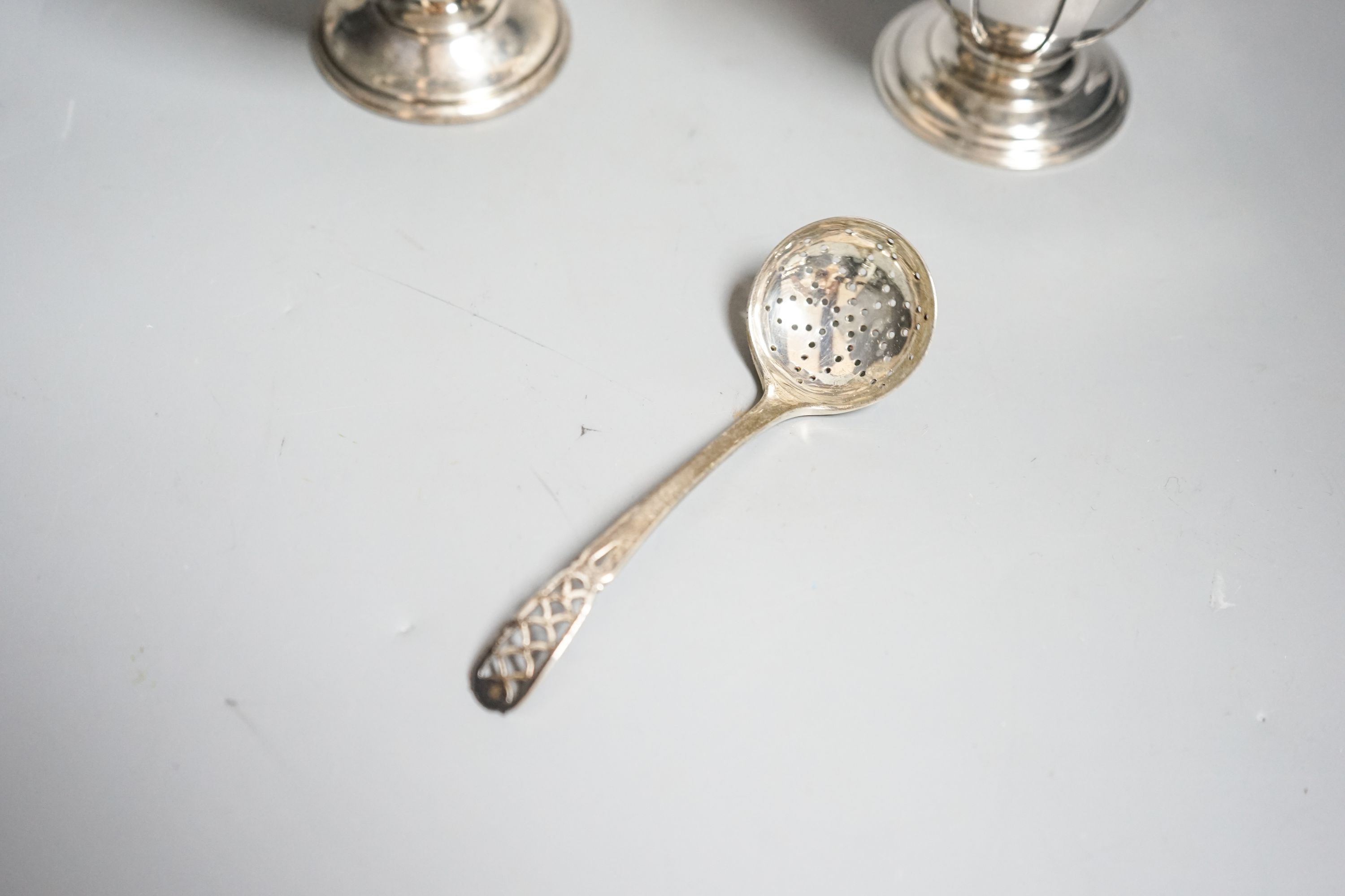 A modern silver sugar basket and sifter spoons, with glass liner by Mappin & Webb, 9.8cm and an earlier silver cream jug by William Comyns & Sons Ltd.